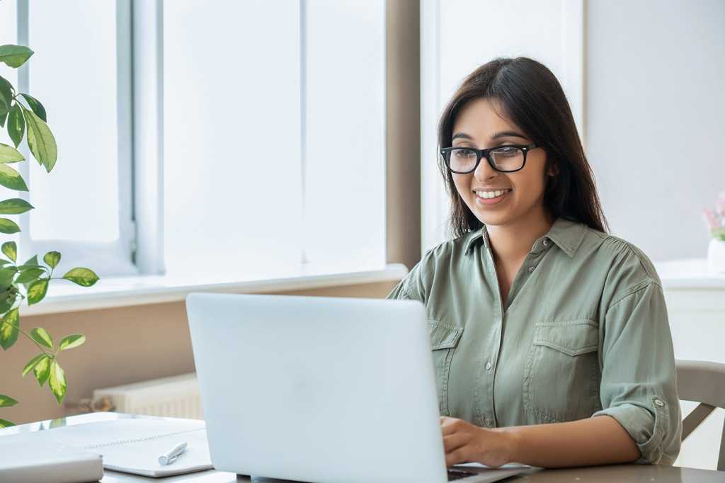 happy worker at laptop by ground picture via shutterstock